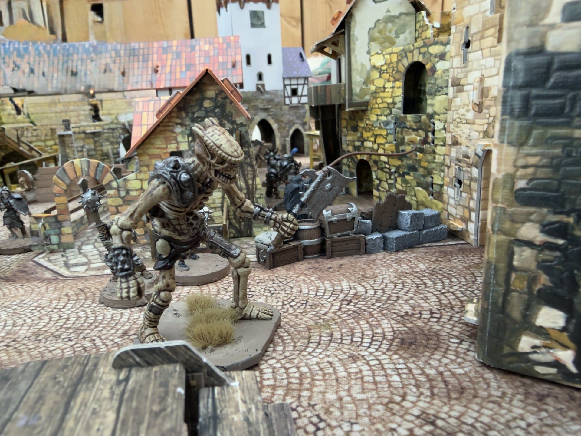 Mordheim potje op de club, een skelet reus tussen de huizen van de stad