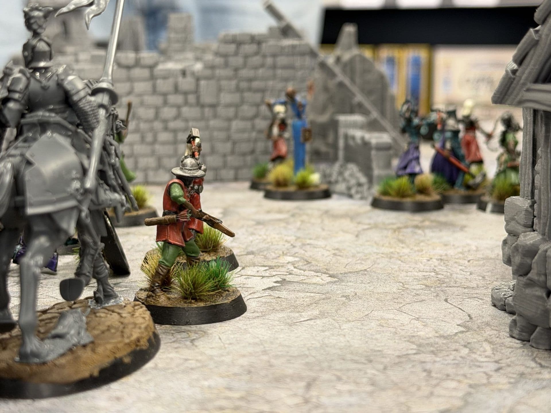 Close-up van miniaturen op een gebarsten straat, met een ruiter en een schutter met kruisboog voor stenen ruïnes